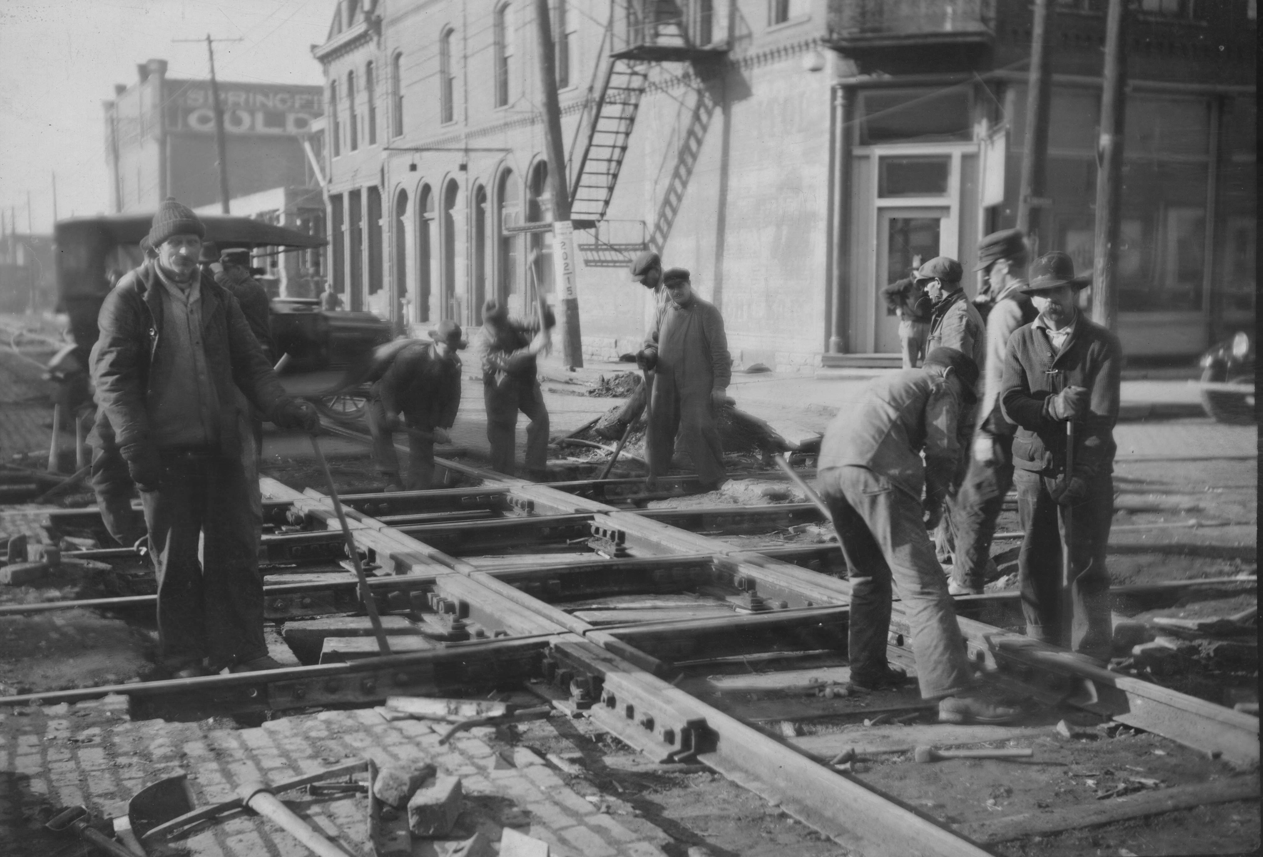 Greyscale photo of tram tracks workers